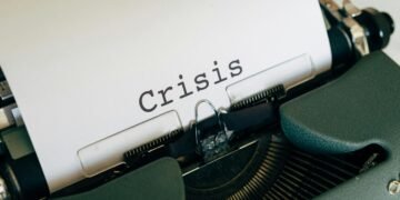Close-up of a vintage typewriter with the word 'Crisis' typed on paper.