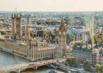 Stunning aerial view of London's iconic Big Ben and the river Thames under daylight.