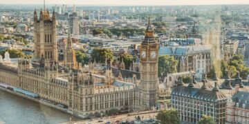 Stunning aerial view of London's iconic Big Ben and the river Thames under daylight.