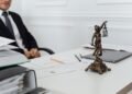 A legal professional's workspace featuring Lady Justice statue, documents, and a laptop.