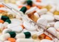 Close-up image showing various pills and a thermometer, emphasizing health and medicine.